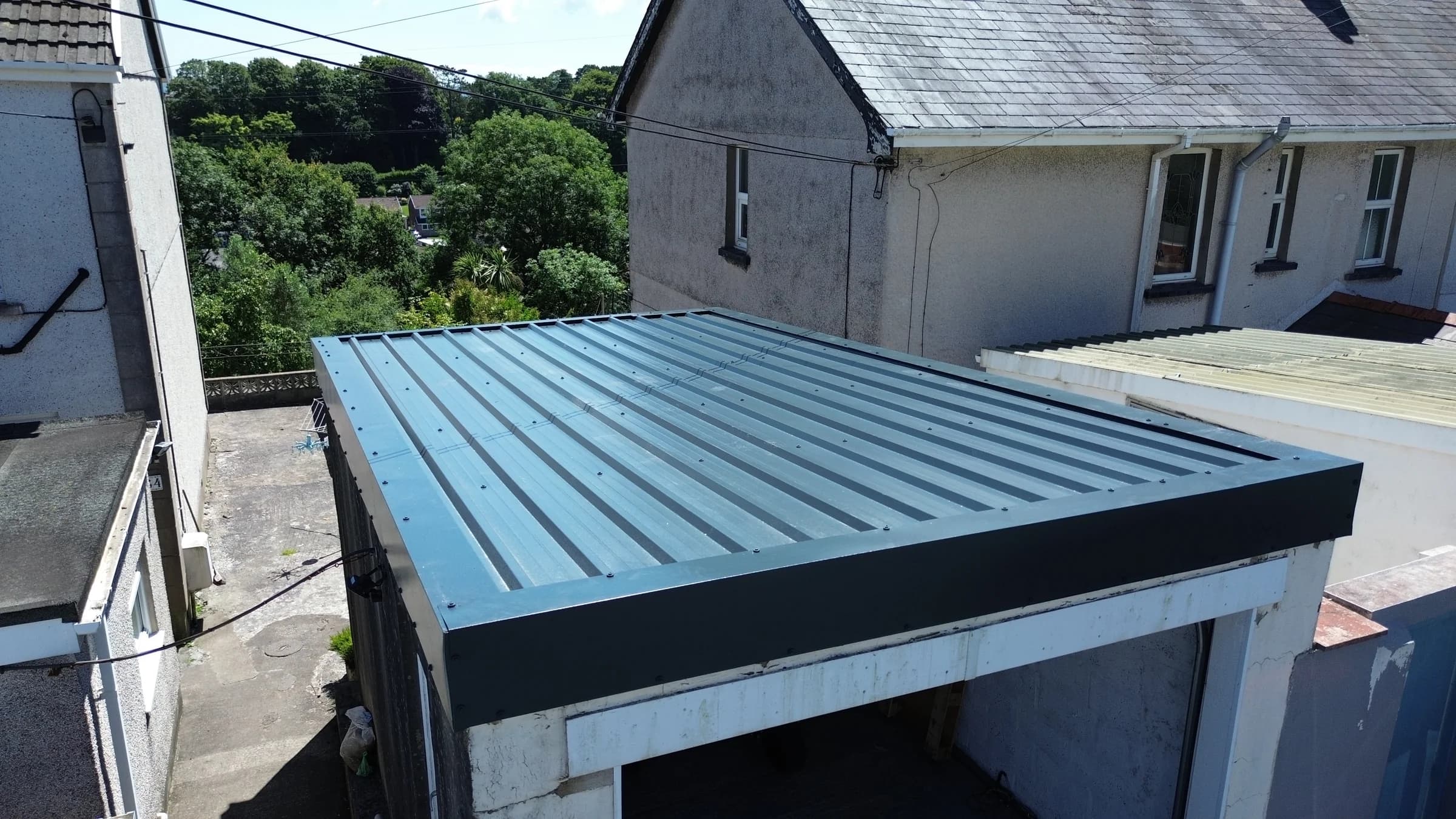Box profile metal roof fitted over a garage and carport in Neath