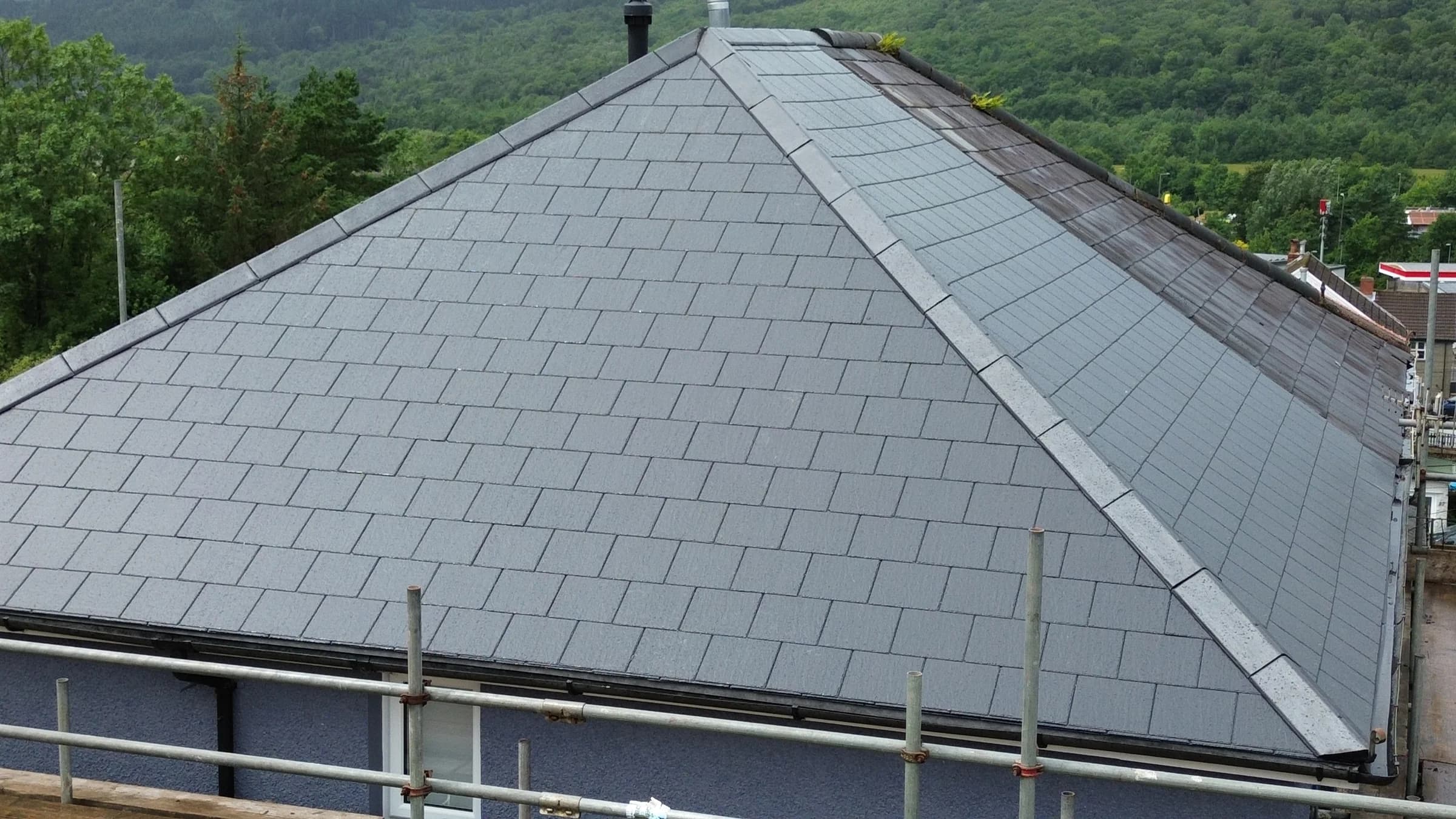 Completed grey slate hipped roof with the valley behind, Neath